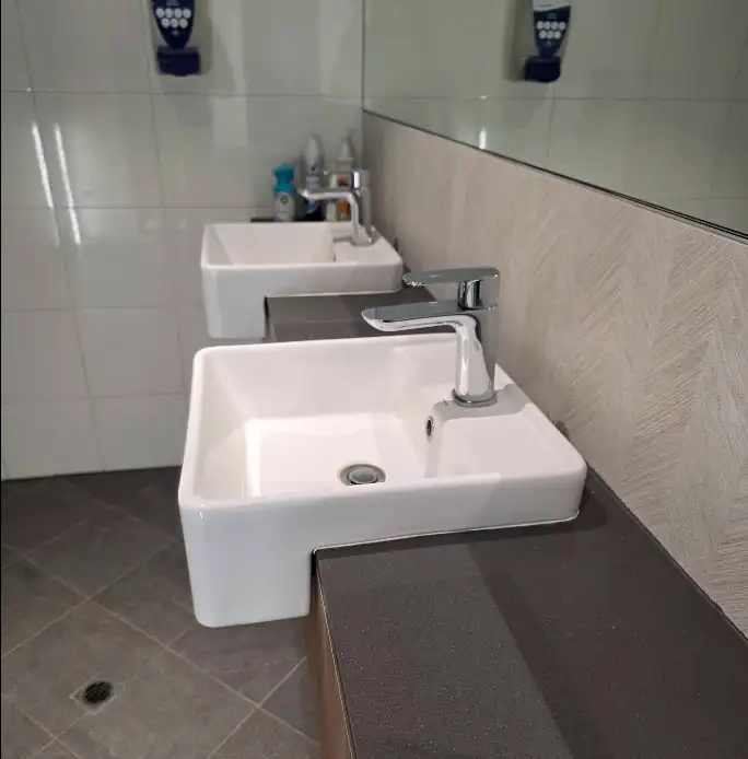 Wall-mounted washroom sinks with chrome tapware